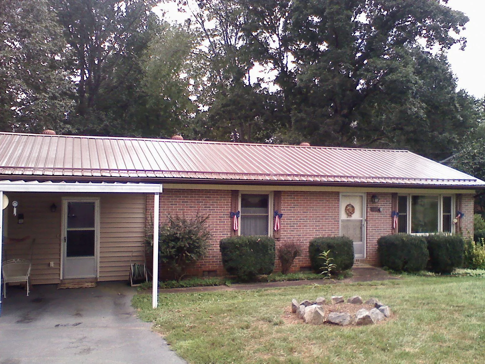 Bronze metal roof and carport on a brick ranch home — Roof Repair work by our crew in Brightwood